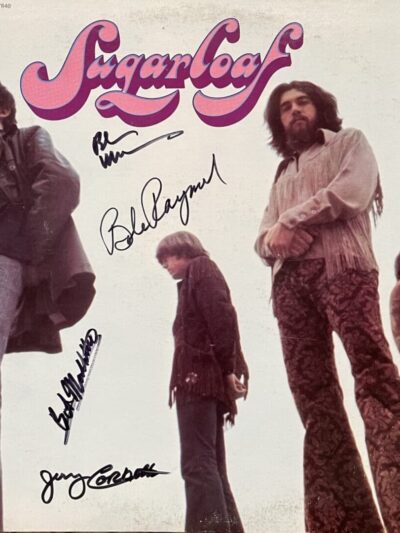 Band members with autographs on album cover.