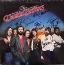 Band members with autographed album cover.
