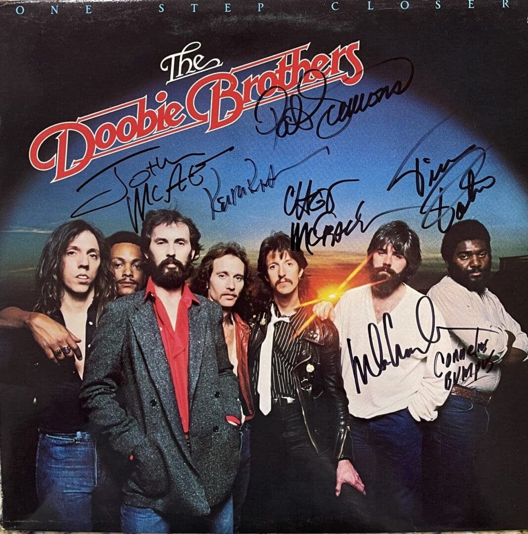 Band members with autographed album cover.