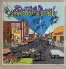 Comic-style album cover with street scene.