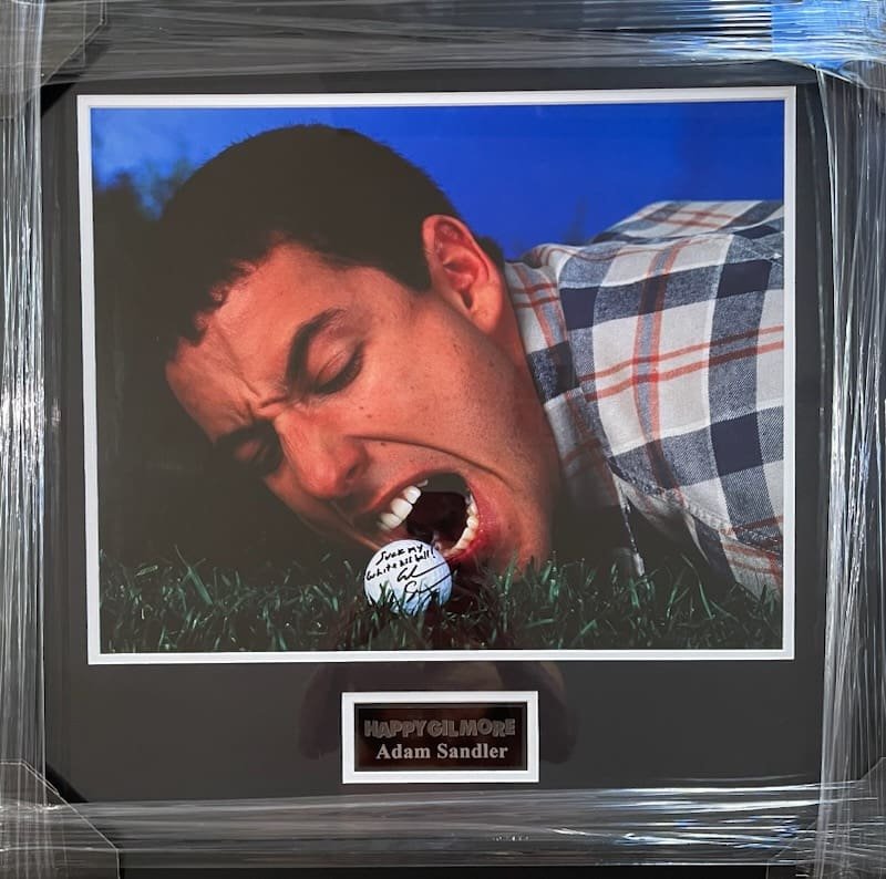 Man biting golf ball on grass.