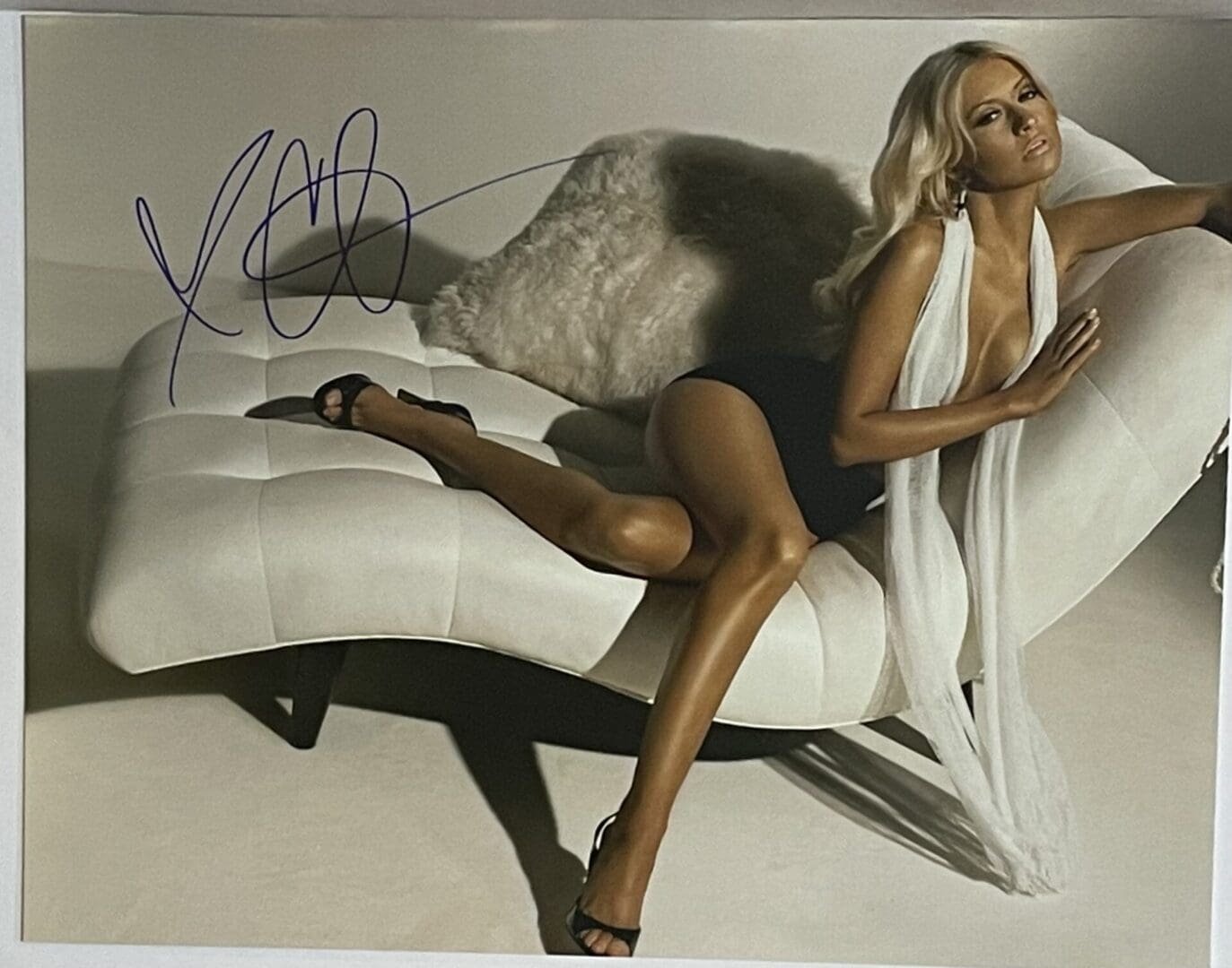 Person posing on a modern white chaise lounge.