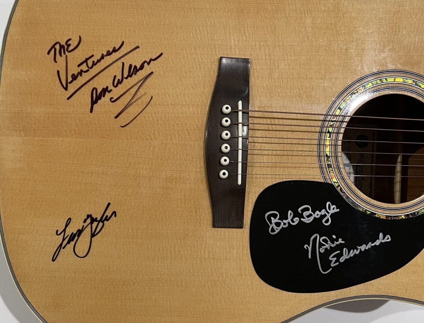 Acoustic guitar with multiple signatures on body.