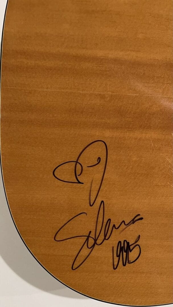 Signed guitar with heart and autograph.