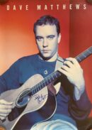Musician playing acoustic guitar against red background.