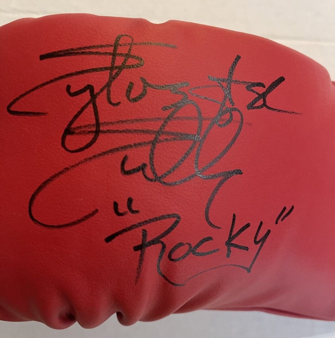 Red boxing glove with black signature.