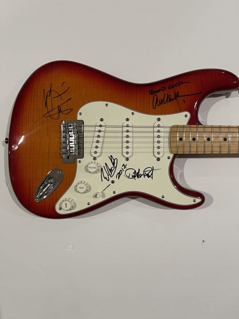 Autographed electric guitar with sunburst finish.