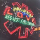Neon sign reading "Unlimited Love" with signatures.