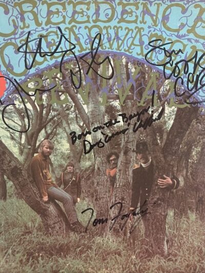 Band members in a forest with autographs.