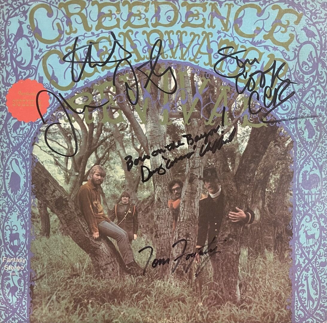 Band members in a forest with autographs.