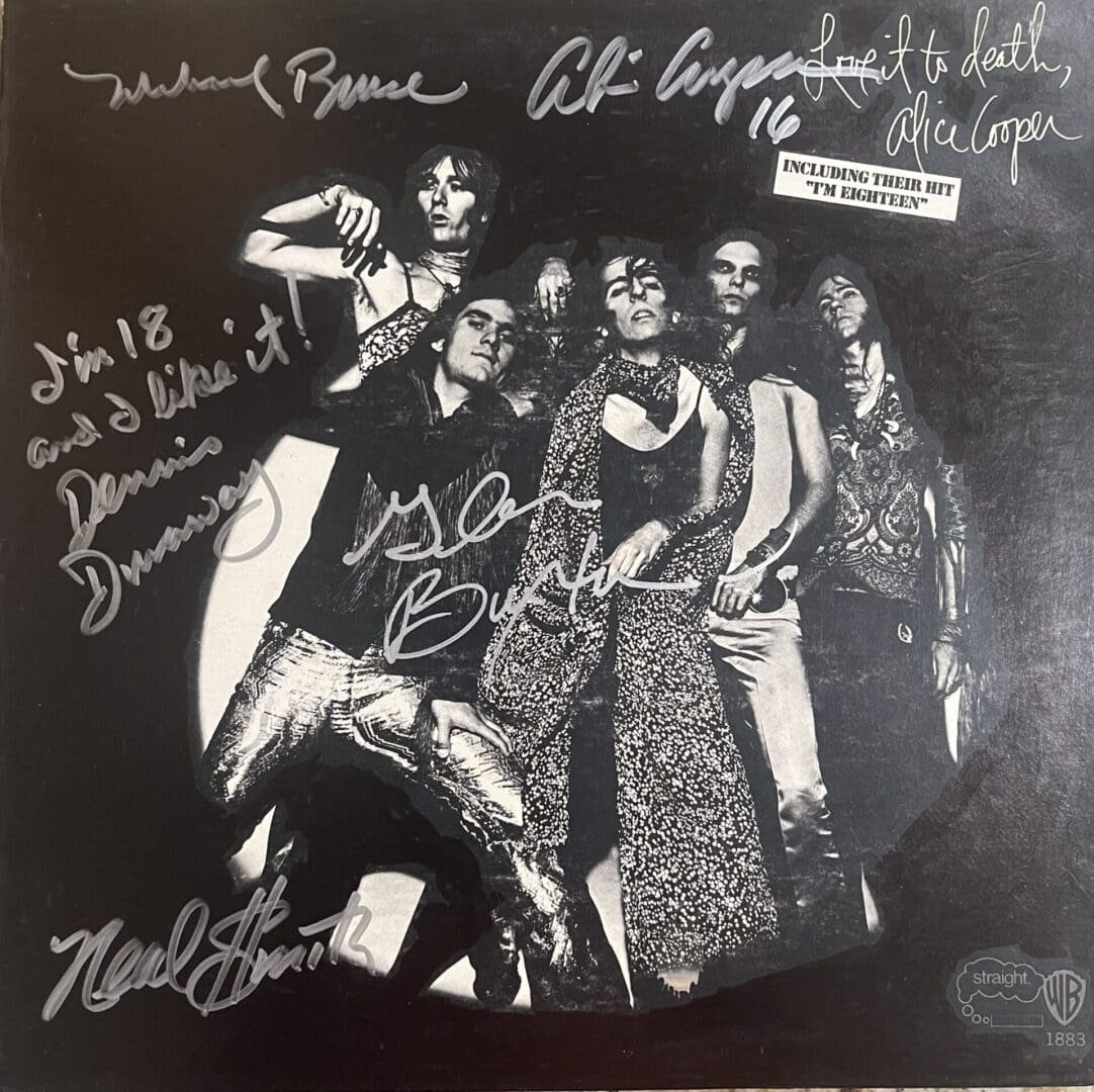 Rock band posing with autographs on album cover.