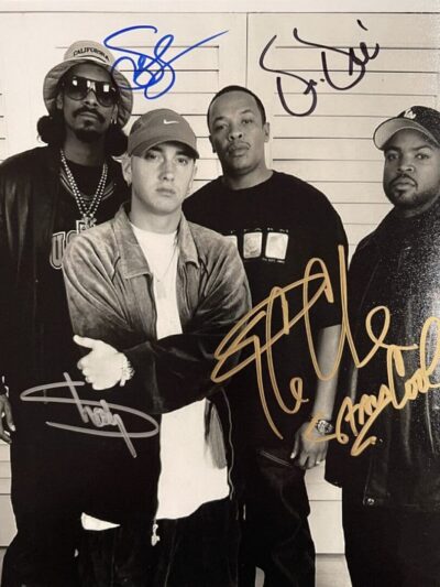 Four men posing with autographs on photo.