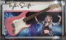 Pink guitar with performer backdrop and signature.