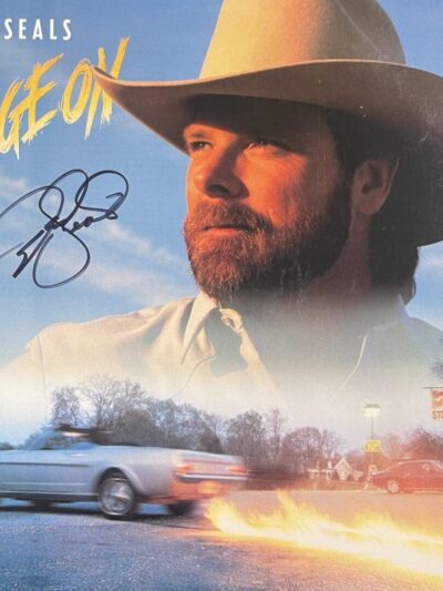 Man in cowboy hat with moving car.