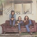 Three men sitting on a vintage couch.