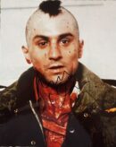 Man with mohawk and signed photograph.