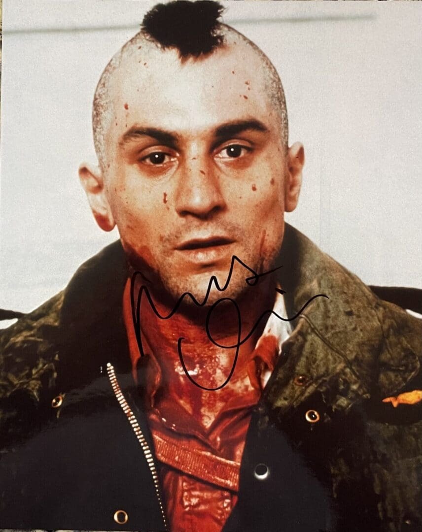 Man with mohawk and signed photograph.