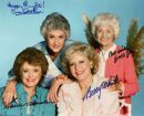 Four women posing with signed autographs.