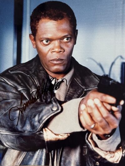 Man in leather jacket holding a gun.