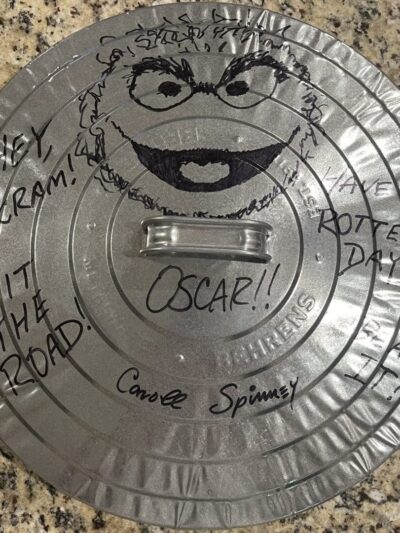 Metal lid with Oscar the Grouch drawing.