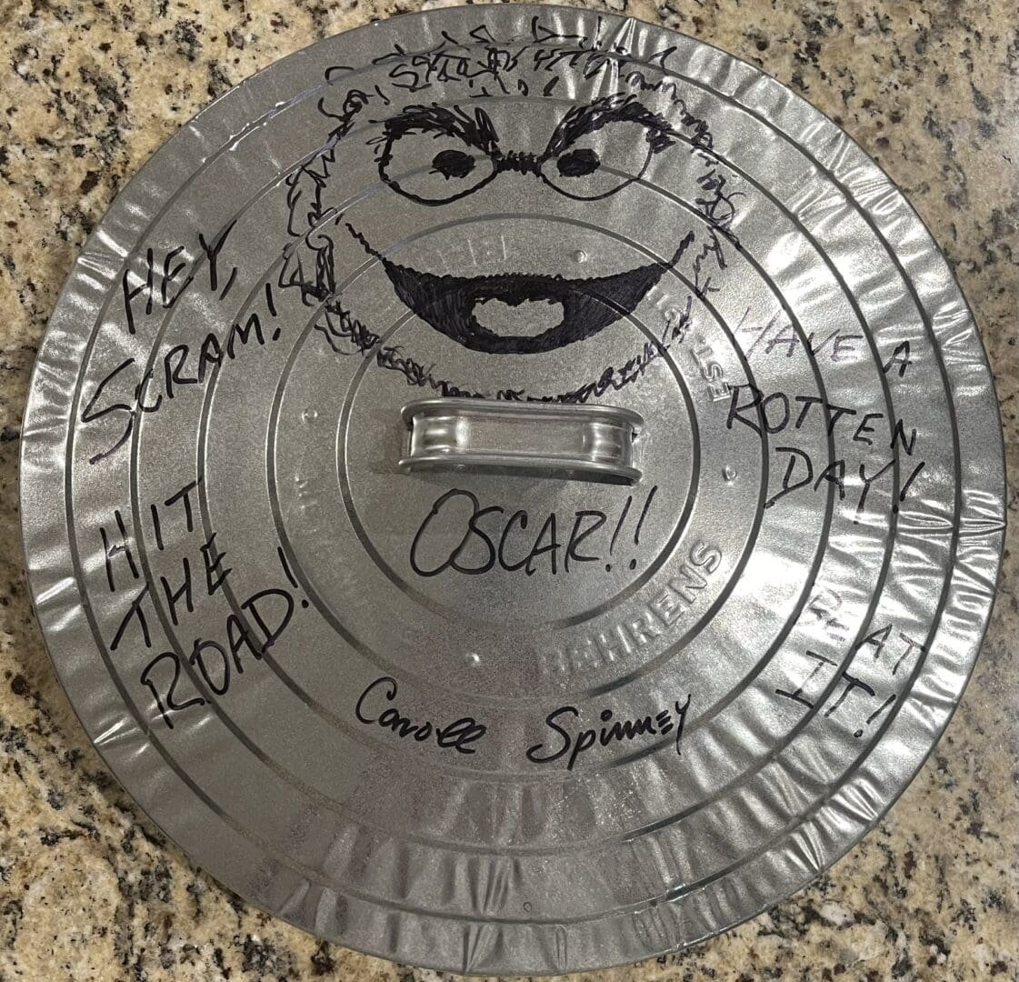 Metal lid with Oscar the Grouch drawing.