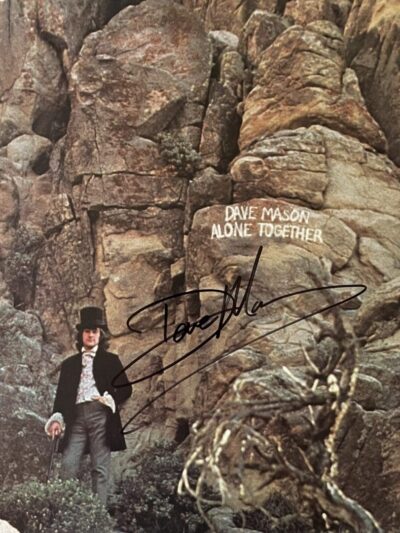Man in top hat by rocky cliff background.