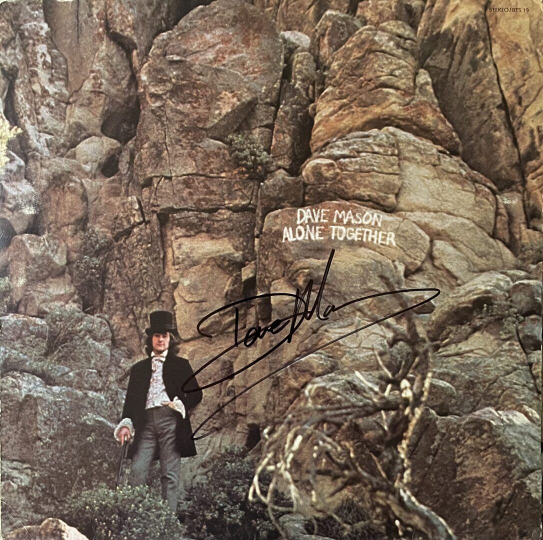 Man in top hat by rocky cliff background.