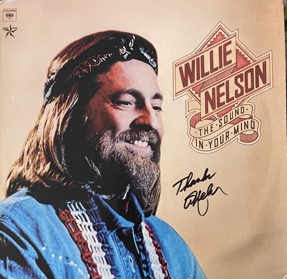 Smiling man on album cover with autograph.