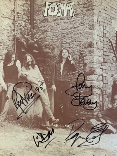 Band members posing by a brick wall.