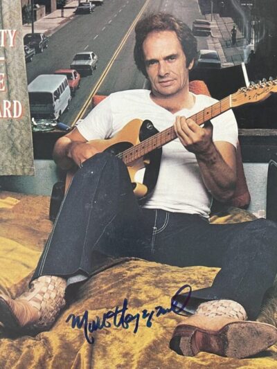 Man playing guitar beside a window.