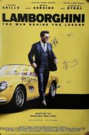 Man in suit beside yellow Lamborghini car.