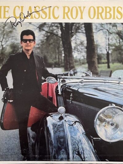 Man standing beside vintage car outdoors.