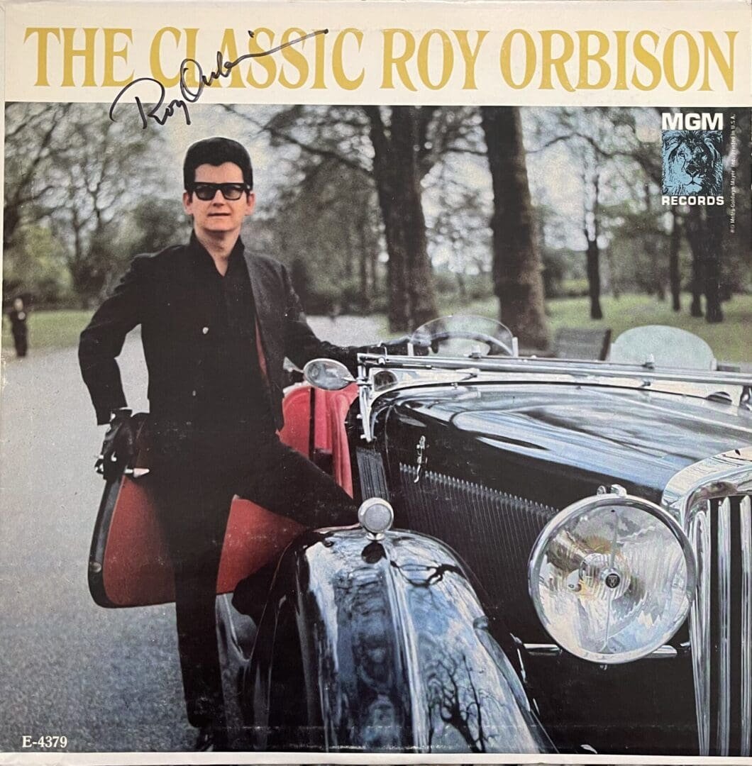 Man standing beside vintage car outdoors.