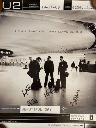 U2 album poster with band signatures.