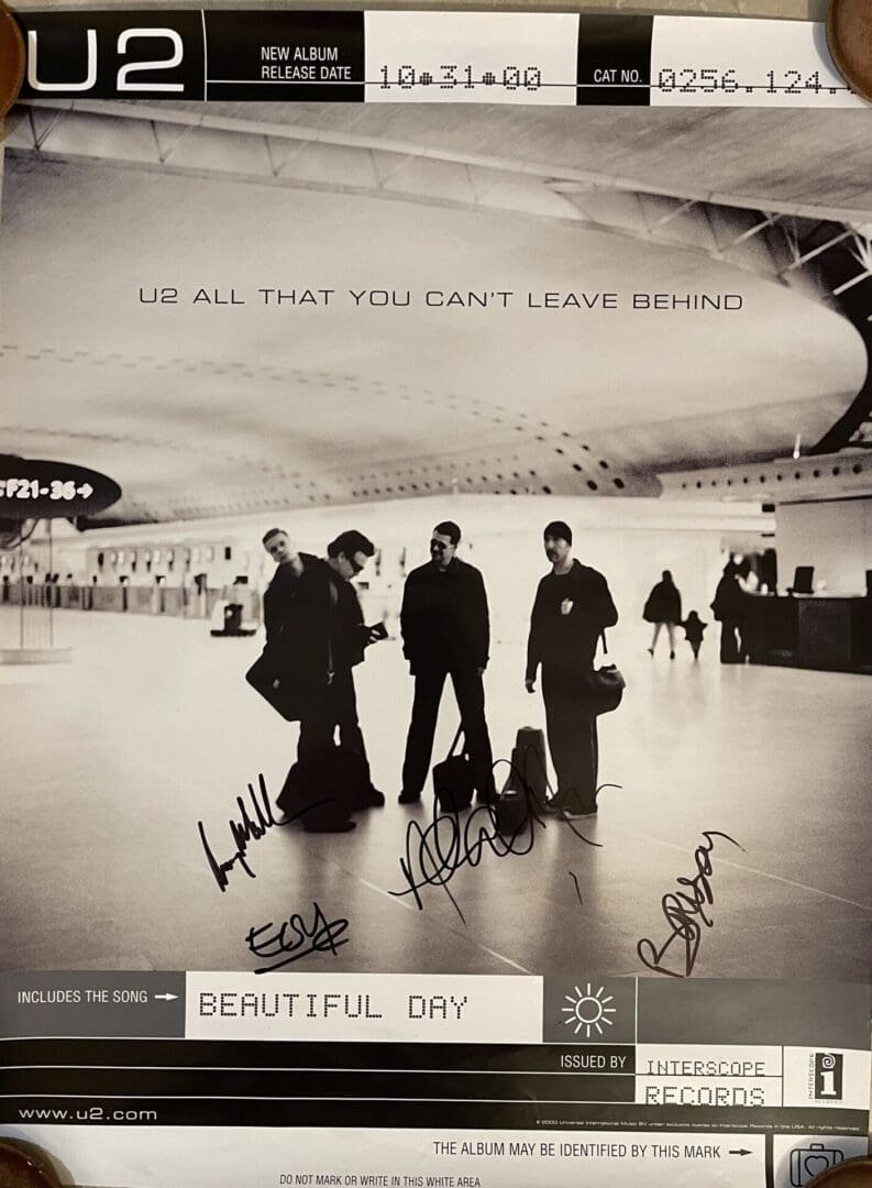 U2 album poster with band signatures.