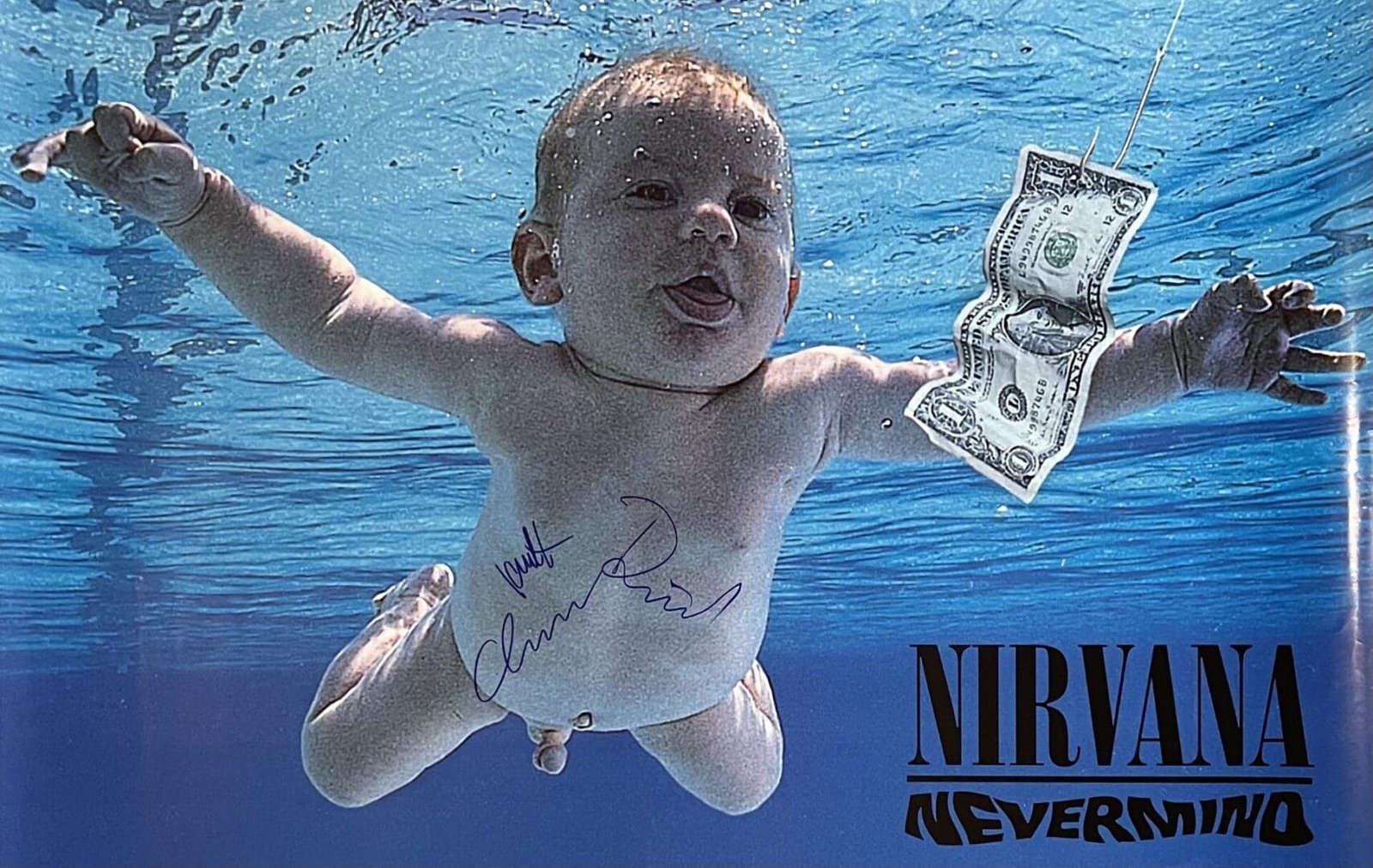 Baby swimming underwater towards dollar bill.