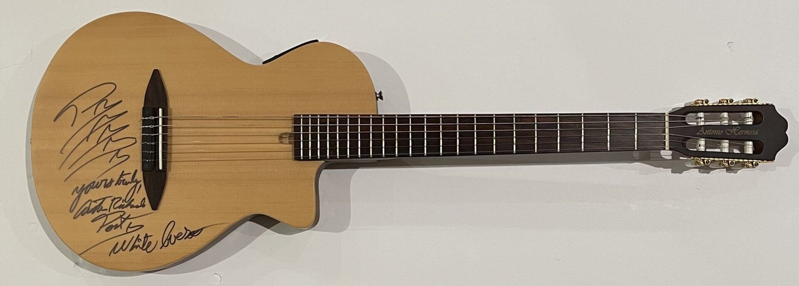 Autographed acoustic guitar on a white background.