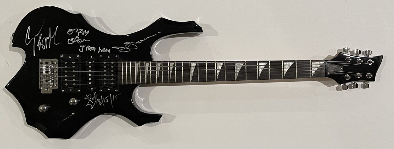 Black electric guitar with autographs on body.