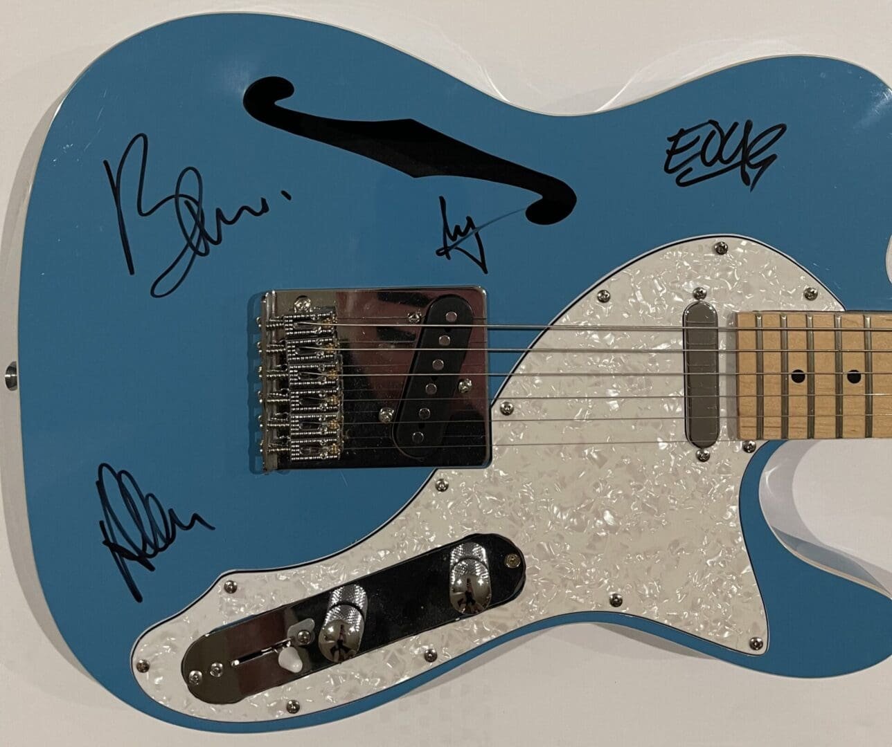 Blue guitar with signatures on the body.