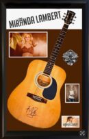 Signed guitar with photos and name displayed.