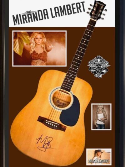 Signed guitar with photos and name displayed.
