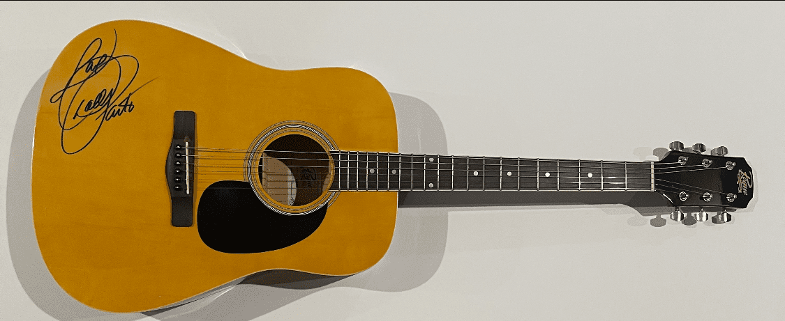 Signed acoustic guitar on white background.