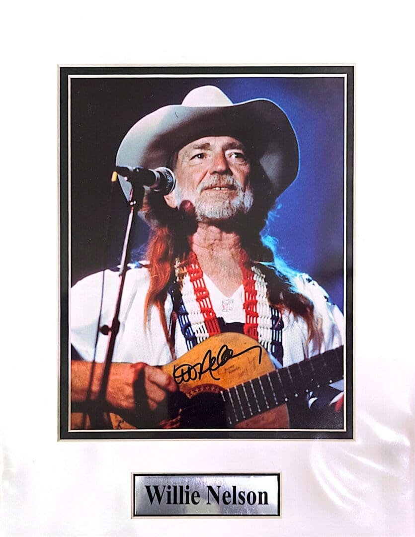 Singer with guitar and cowboy hat performing.
