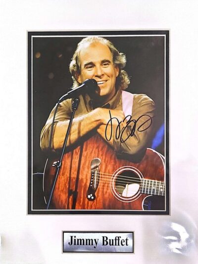 Man smiling with guitar on stage.