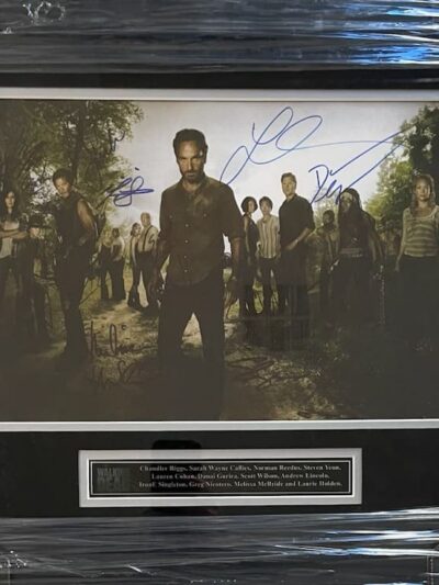 Framed autographed photo with multiple people.