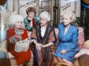 Four women sitting on a floral couch.
