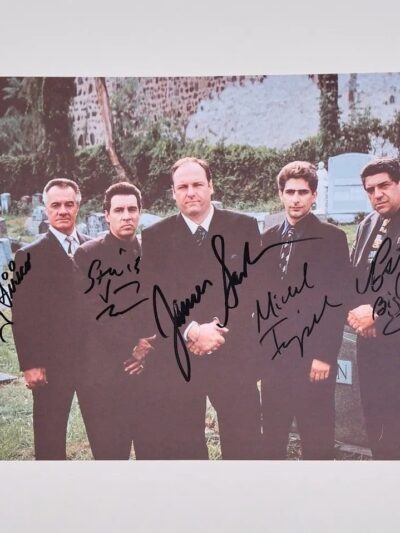 Five men in suits at a cemetery.