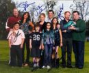 Family group photo with autographs on grass.