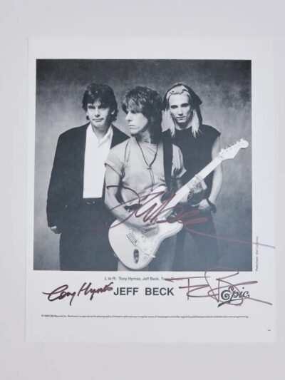 Three people posing with a guitar.