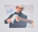 Man in cowboy hat holding electric guitar.